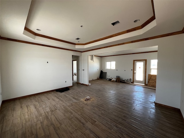 unfurnished living room with ornamental molding, dark hardwood / wood-style floors, and a raised ceiling