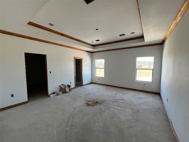 empty room featuring plenty of natural light, crown molding, and a tray ceiling