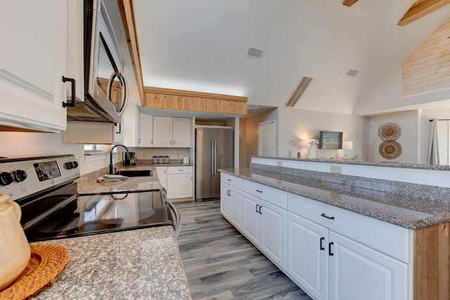 kitchen with stainless steel appliances, light hardwood / wood-style floors, white cabinets, sink, and high vaulted ceiling