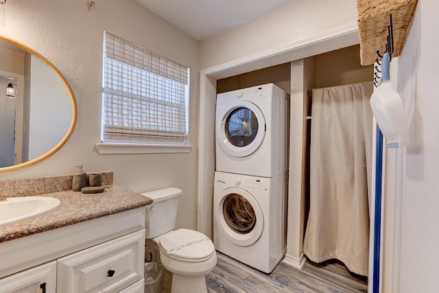 2332 Martinique, Crystal Beach, TX 77650 - bathroom featuring stacked washer and clothes dryer, wood finished floors, toilet, and vanity