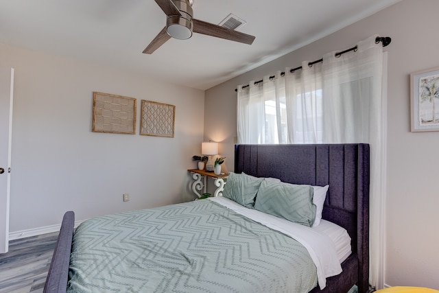 bedroom with wood finished floors, visible vents, and a ceiling fan