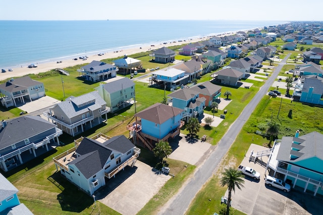 drone / aerial view featuring a beach view, a water view, and a residential view