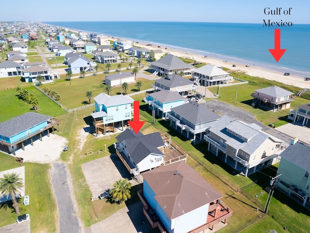 drone / aerial view featuring a beach view and a water view