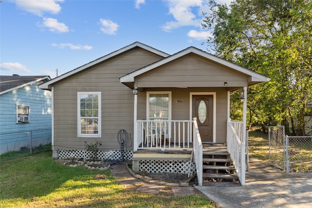 bungalow-style home featuring a front lawn and covered porch