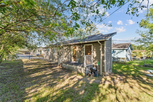 rear view of house featuring a lawn and a wooden deck