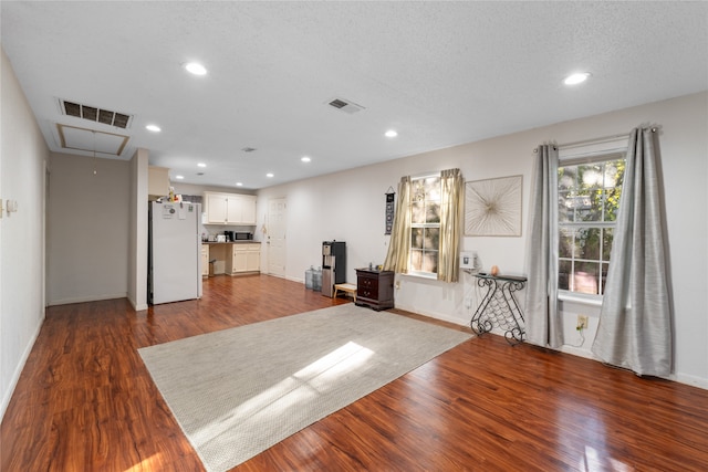 interior space featuring a textured ceiling and hardwood / wood-style floors