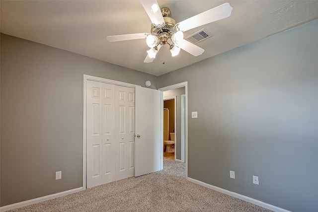 unfurnished bedroom with ceiling fan, carpet floors, and a closet