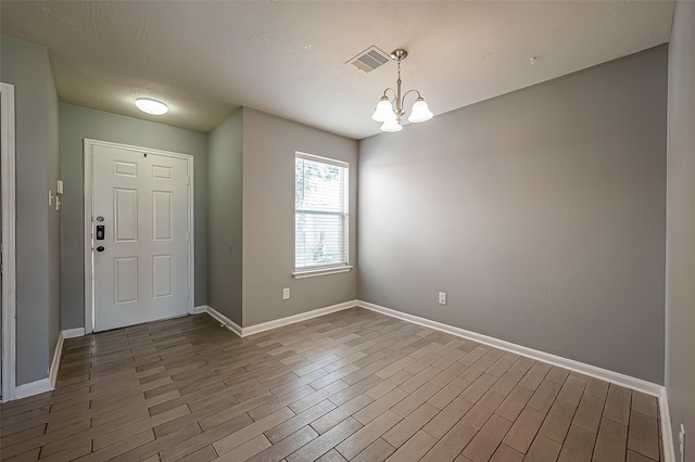 entrance foyer featuring an inviting chandelier and dark hardwood / wood-style flooring