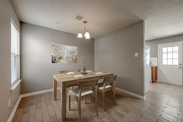 dining area featuring a notable chandelier and light hardwood / wood-style flooring