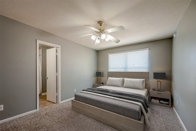 carpeted bedroom featuring ceiling fan and a textured ceiling