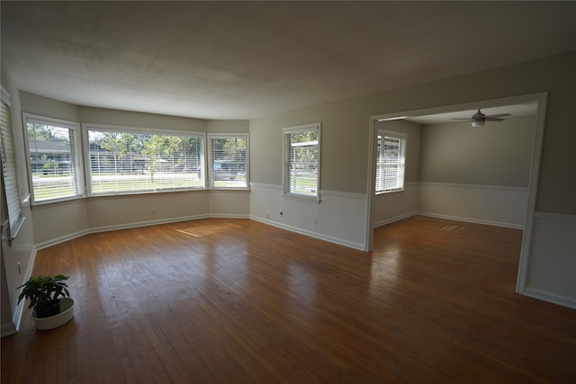 empty room with dark hardwood / wood-style floors and ceiling fan