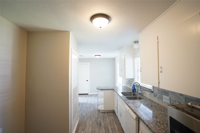 kitchen featuring light stone counters, white dishwasher, sink, white cabinetry, and light wood-type flooring