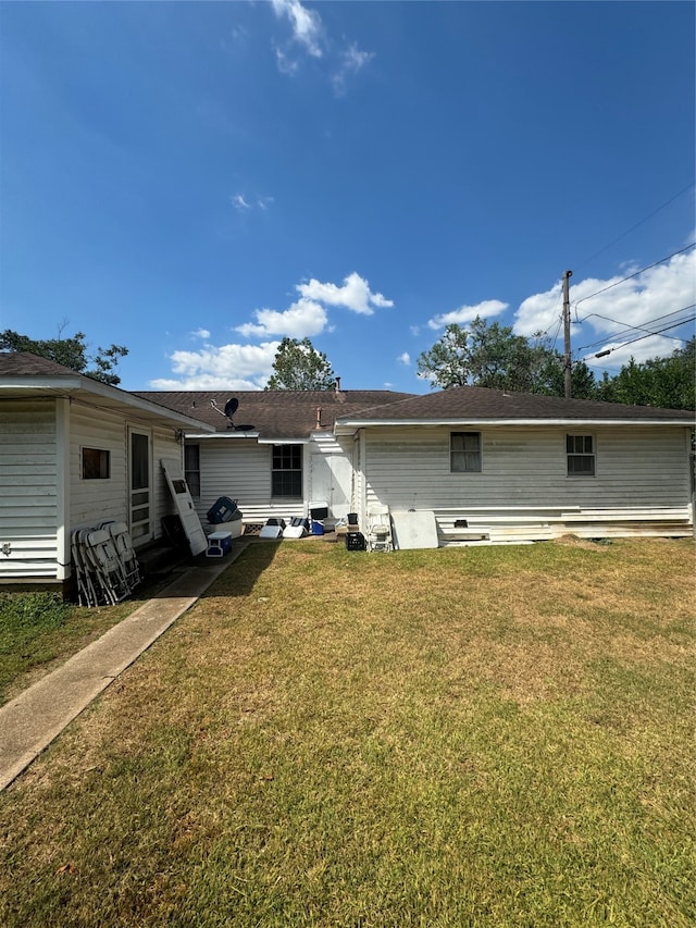 rear view of property with a lawn