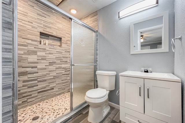 bathroom with hardwood / wood-style floors, a shower with shower door, vanity, and toilet