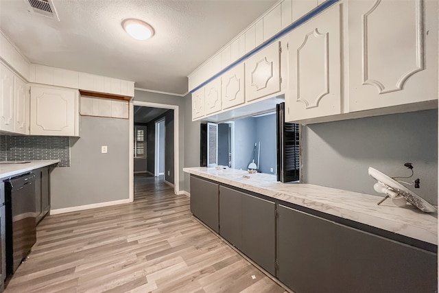 kitchen with white cabinetry, backsplash, black dishwasher, light wood-type flooring, and a textured ceiling