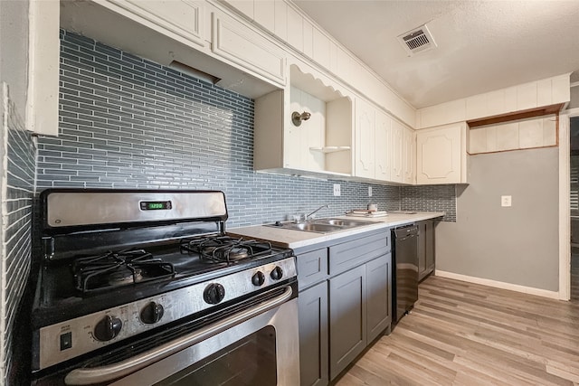 kitchen featuring sink, stainless steel range with gas stovetop, light hardwood / wood-style flooring, backsplash, and black dishwasher