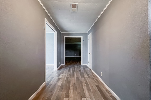 hallway with ornamental molding and hardwood / wood-style flooring