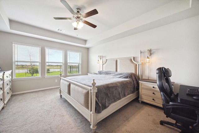 bedroom with a tray ceiling, carpet floors, and ceiling fan