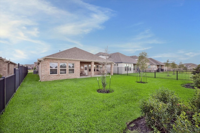 back of house with a patio area and a lawn