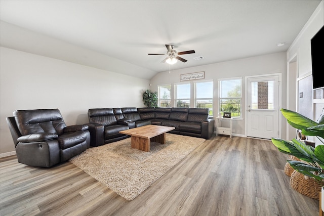 living room featuring light hardwood / wood-style flooring, lofted ceiling, and ceiling fan