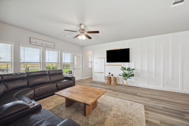 living room with wood-type flooring and ceiling fan