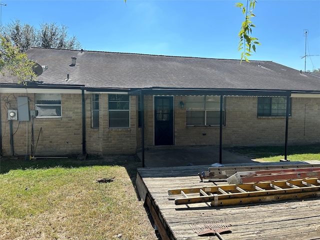 rear view of house with a wooden deck and a yard