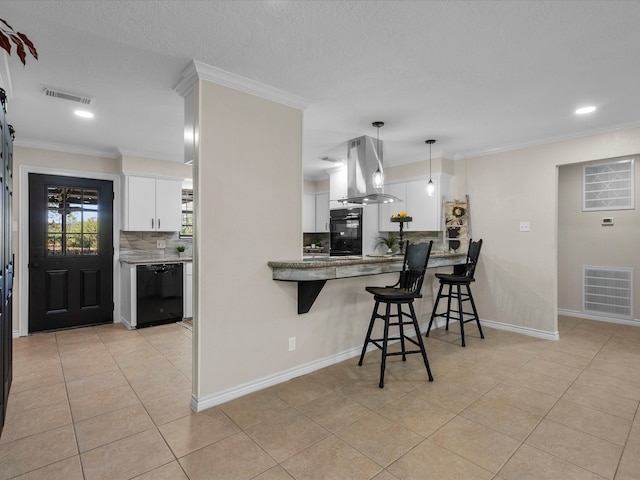 kitchen featuring kitchen peninsula, a breakfast bar area, island range hood, white cabinets, and black appliances