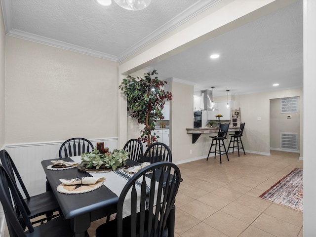 dining space featuring a textured ceiling, light tile patterned floors, and crown molding