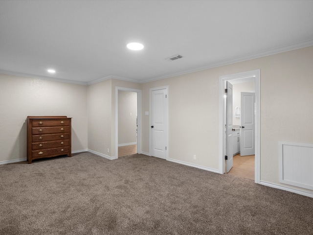 unfurnished bedroom featuring crown molding, light carpet, and ensuite bath