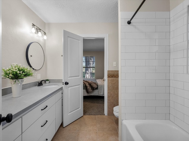 full bathroom featuring tile patterned floors, a textured ceiling, toilet, vanity, and tile walls