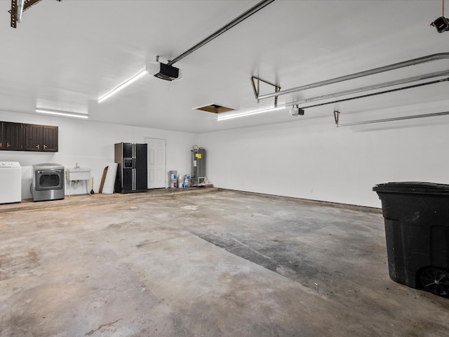 garage featuring washing machine and dryer, electric water heater, sink, and a garage door opener