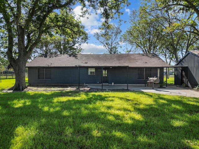 rear view of property with a yard and a patio