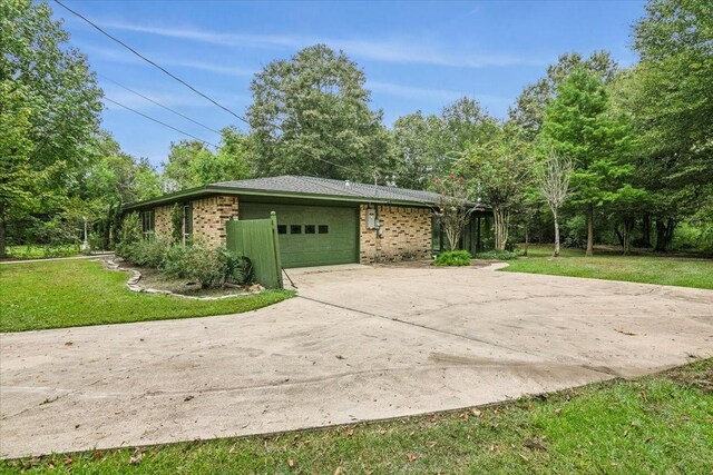 3301 Pelican St, Orange, TX 77630 - view of side of property featuring an attached garage, concrete driveway, brick siding, and a yard