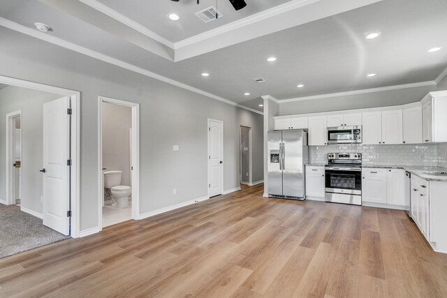 kitchen with white cabinets, appliances with stainless steel finishes, and light wood-type flooring