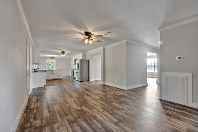 unfurnished living room featuring dark hardwood / wood-style flooring, crown molding, and a wealth of natural light