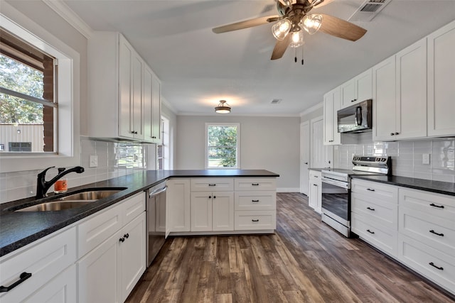 kitchen featuring stainless steel appliances, white cabinetry, sink, and kitchen peninsula