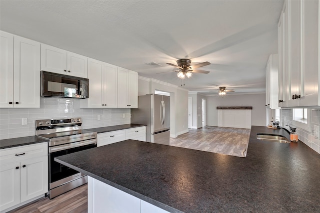 kitchen featuring stainless steel appliances, sink, white cabinets, and kitchen peninsula