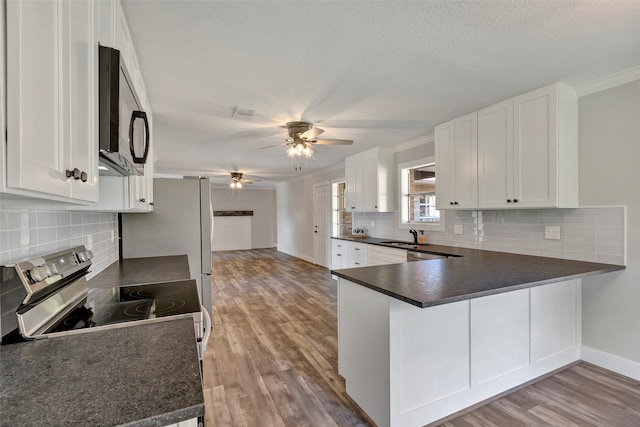 kitchen with white cabinetry, light hardwood / wood-style flooring, and kitchen peninsula