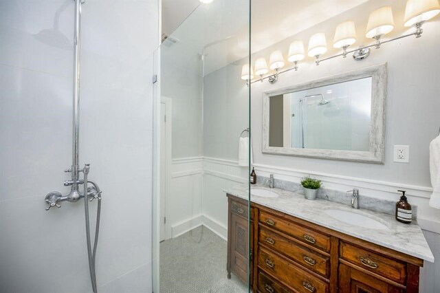 bathroom featuring a shower with door and vanity