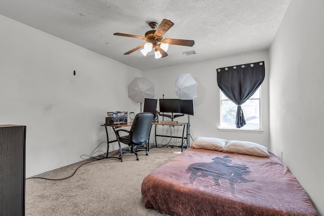 carpeted bedroom with a textured ceiling and ceiling fan