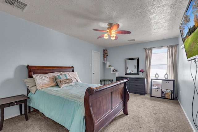 carpeted bedroom featuring a textured ceiling and ceiling fan