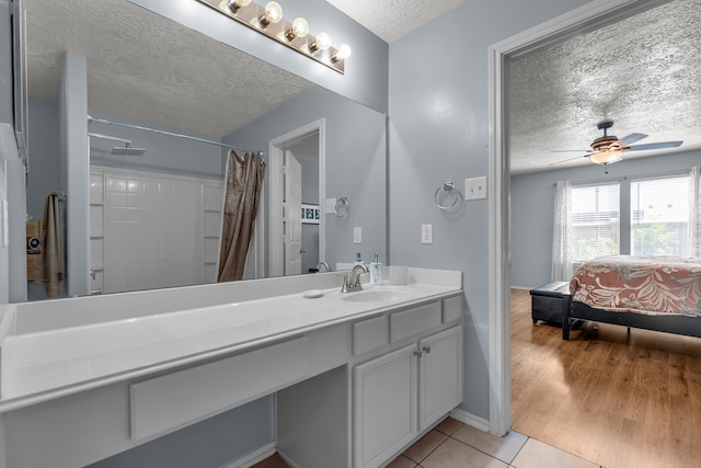 bathroom with vanity, a textured ceiling, a shower with shower curtain, ceiling fan, and hardwood / wood-style flooring