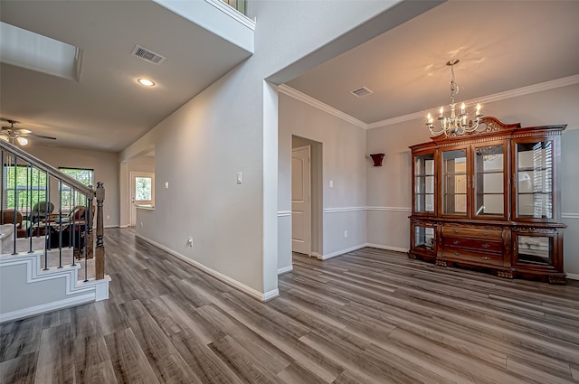 interior space featuring ceiling fan with notable chandelier, ornamental molding, and hardwood / wood-style floors