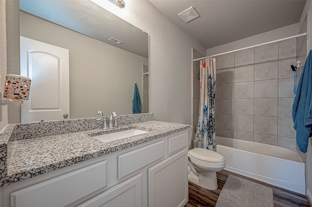 full bathroom with shower / bath combination with curtain, hardwood / wood-style flooring, vanity, and toilet