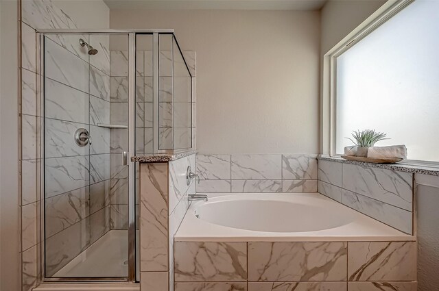 bathroom featuring shower with separate bathtub