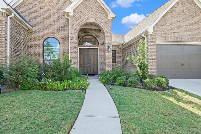 doorway to property with a garage and a lawn