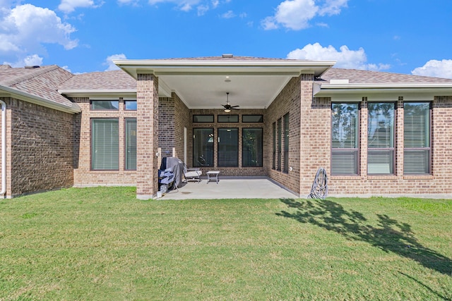 rear view of house featuring ceiling fan, a lawn, and a patio area