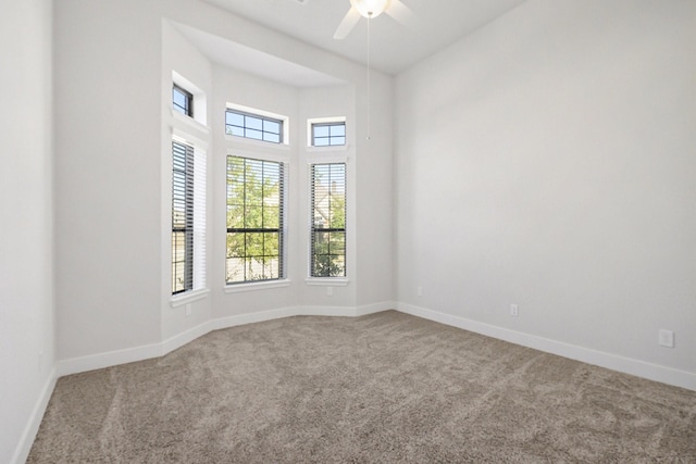 empty room featuring carpet floors, baseboards, and a ceiling fan