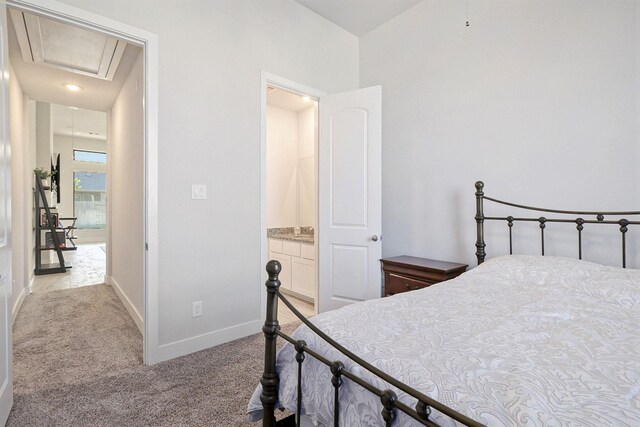 bedroom featuring light carpet and ensuite bath