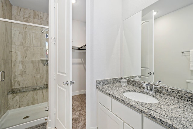 bathroom featuring walk in shower and vanity